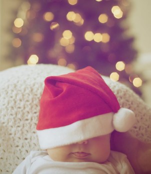 close up of illuminated christmas tree and a baby